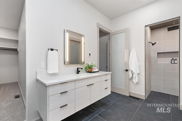 3359 E Warm Springs Ave, Boise, ID 83716 - bathroom featuring vanity, a tile shower, and tile patterned flooring