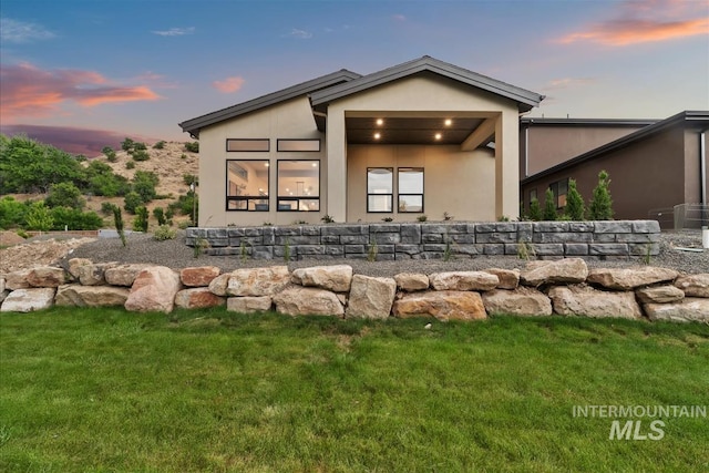 3359 E Warm Springs Ave, Boise, ID 83716 - rear view of house with stucco siding and a yard