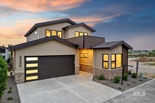 3359 E Warm Springs Ave, Boise, ID 83716 - modern home with stone siding, a garage, stucco siding, and driveway