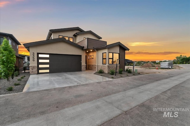 3359 E Warm Springs Ave, Boise, ID 83716 - contemporary house with stone siding, a garage, stucco siding, and driveway