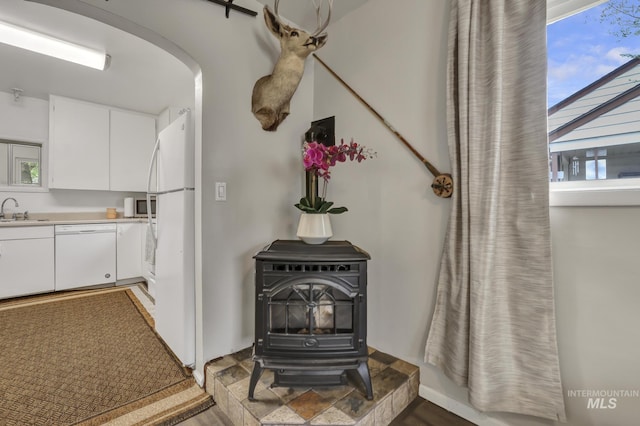 420 E 3rd St, Shoshone, ID 83352 - detailed view of white appliances, a sink, a wood stove, and arched walkways