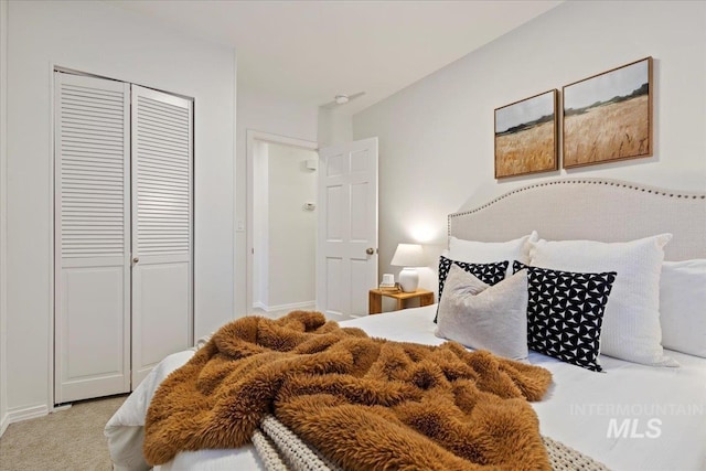 bedroom featuring light colored carpet and a closet