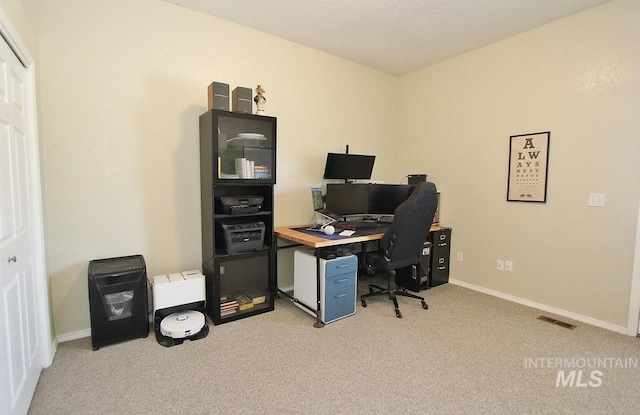 home office featuring baseboards, light carpet, and visible vents