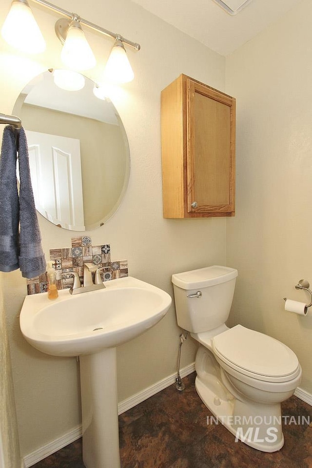 bathroom with baseboards and toilet
