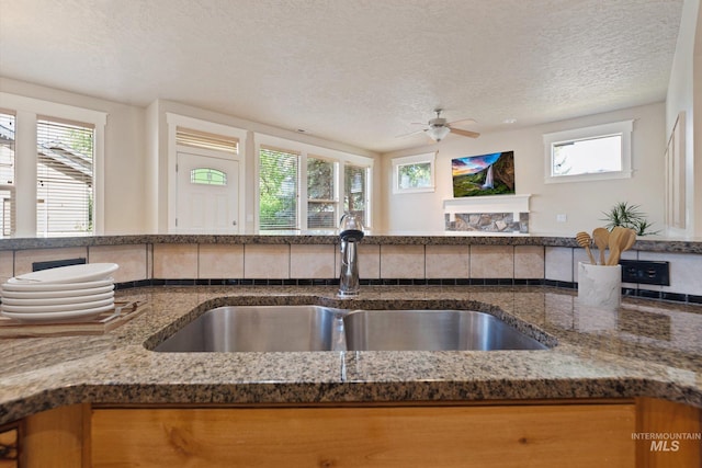 3993 N Heritage View Ave, Meridian, ID 83646 - kitchen with a sink, dark stone countertops, plenty of natural light, and a textured ceiling