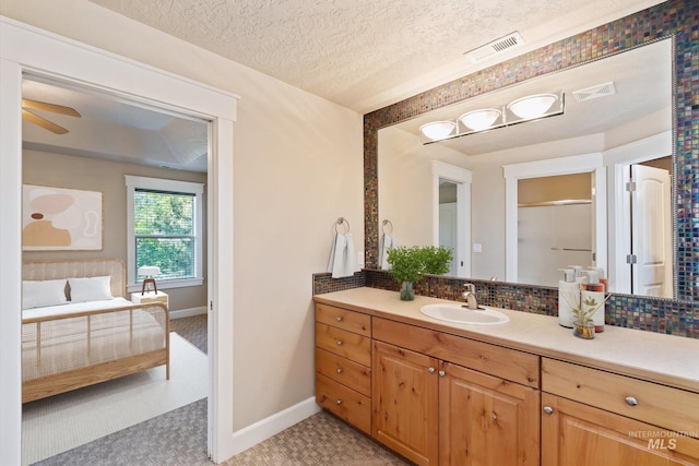 3993 N Heritage View Ave, Meridian, ID 83646 - bathroom with vanity, baseboards, decorative backsplash, a ceiling fan, and a textured ceiling