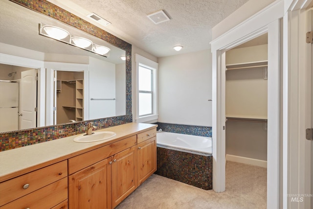 3993 N Heritage View Ave, Meridian, ID 83646 - bathroom with a walk in closet, vanity, a bath, a stall shower, and a textured ceiling