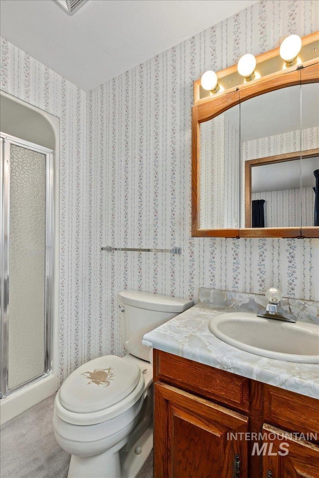 full bath with a shower stall, wallpapered walls, vanity, and toilet