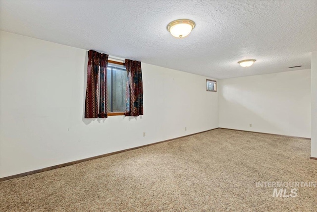 basement with a textured ceiling, baseboards, and carpet floors