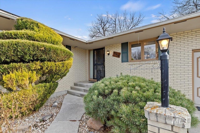 view of exterior entry featuring brick siding