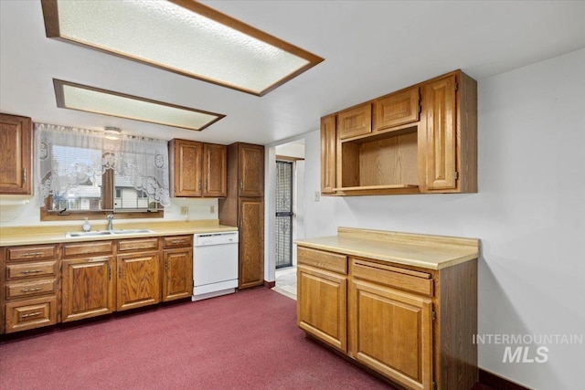 kitchen with light countertops, brown cabinets, white dishwasher, and a sink