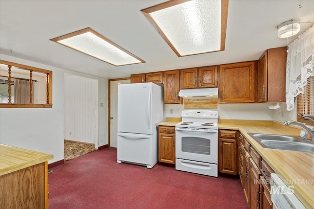 kitchen featuring a sink, white appliances, brown cabinetry, and light countertops