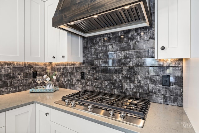 12975 Silversage Dr, Nampa, ID 83686 - kitchen featuring custom exhaust hood, stainless steel gas cooktop, backsplash, and white cabinets
