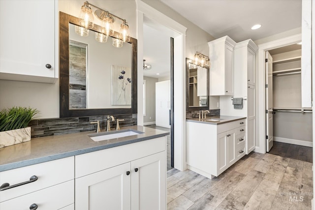 12975 Silversage Dr, Nampa, ID 83686 - bathroom with two vanities, tasteful backsplash, wood finished floors, recessed lighting, and a walk in closet