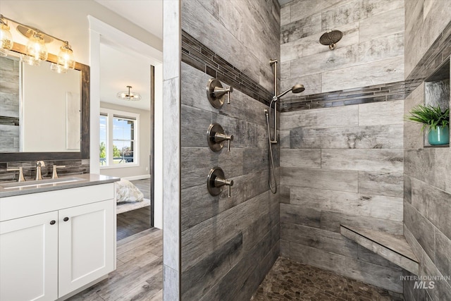12975 Silversage Dr, Nampa, ID 83686 - bathroom featuring a tile shower, vanity, and wood finished floors