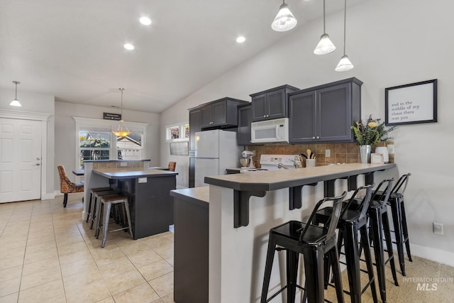 1326 N Alvey, Meridian, ID 83642 - kitchen with white appliances, tasteful backsplash, vaulted ceiling, a breakfast bar area, and a peninsula