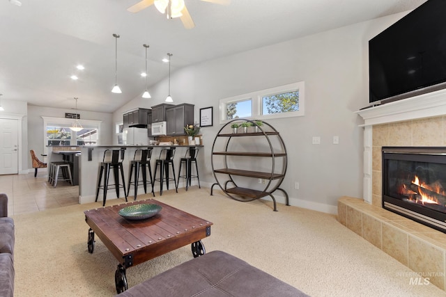 1326 N Alvey, Meridian, ID 83642 - living room with light carpet, a tiled fireplace, ceiling fan, baseboards, and vaulted ceiling