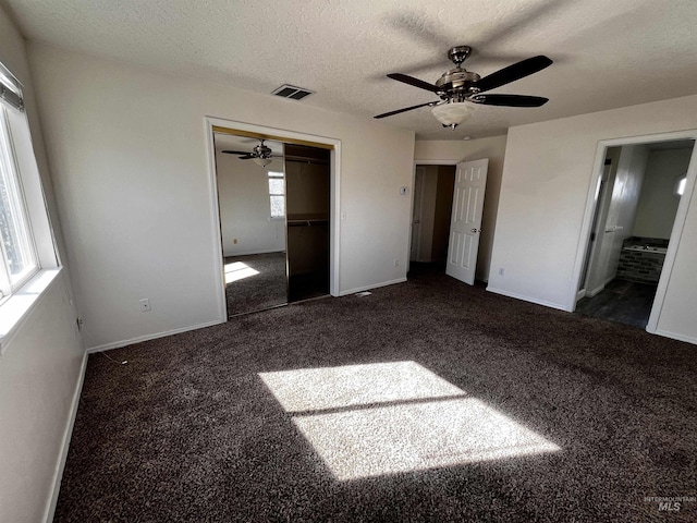 unfurnished bedroom featuring baseboards, carpet flooring, visible vents, and a textured ceiling