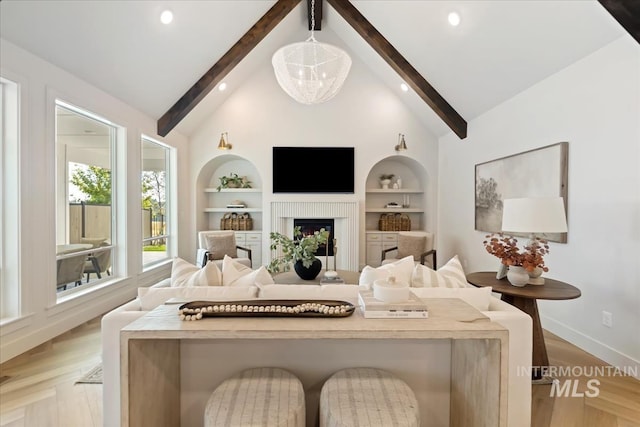 3064 N Wingspan Way, Eagle, ID 83616 - living area with lofted ceiling with beams, built in features, a fireplace, light wood finished floors, and baseboards