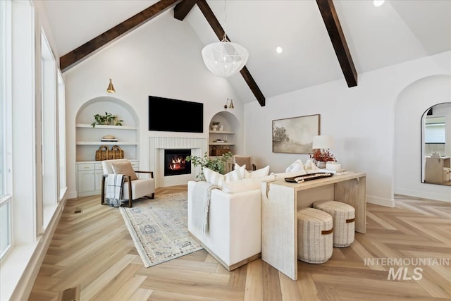 3064 N Wingspan Way, Eagle, ID 83616 - living room featuring baseboards, a glass covered fireplace, built in features, arched walkways, and beamed ceiling