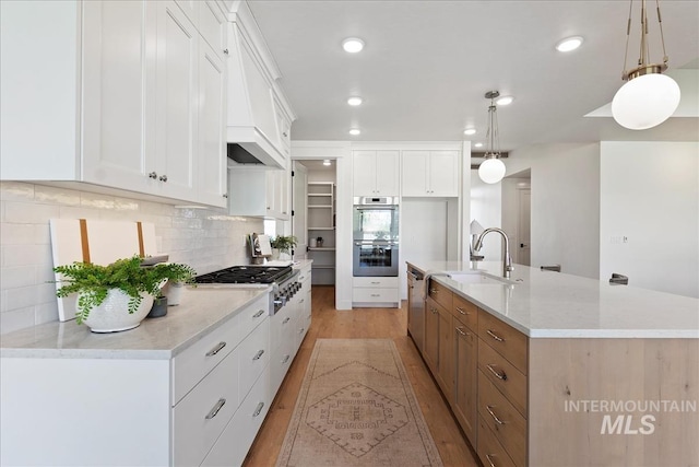 3064 N Wingspan Way, Eagle, ID 83616 - kitchen featuring light wood-style flooring, a sink, decorative backsplash, a center island with sink, and stainless steel appliances