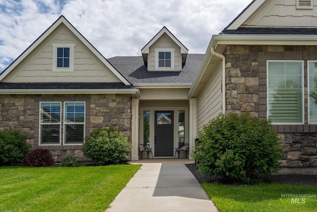 2522 N Foudy Ave, Eagle, ID 83616 - view of exterior entry with stone siding, a yard, and roof with shingles