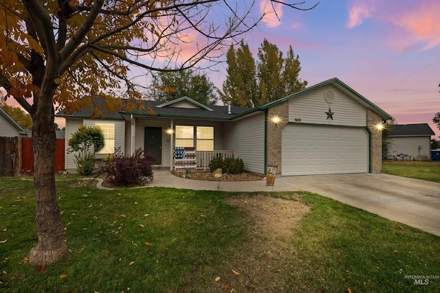 single story home with a yard, covered porch, and a garage