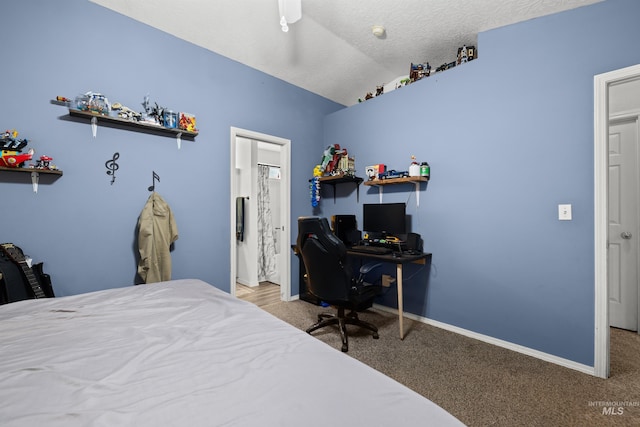 carpeted bedroom featuring vaulted ceiling, a textured ceiling, and ceiling fan