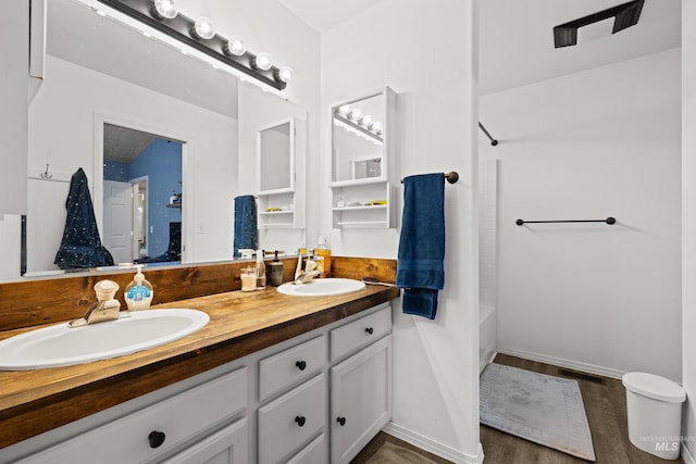 bathroom with vanity, washtub / shower combination, and hardwood / wood-style floors