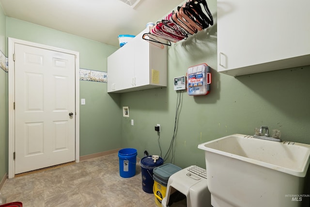 clothes washing area with sink, hookup for a washing machine, and cabinets