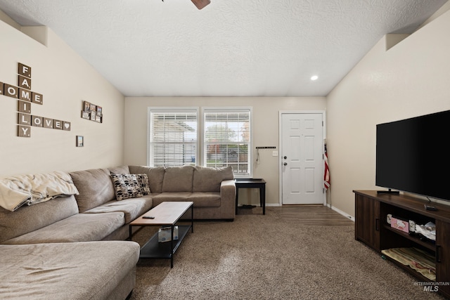 carpeted living room with ceiling fan, a textured ceiling, and vaulted ceiling