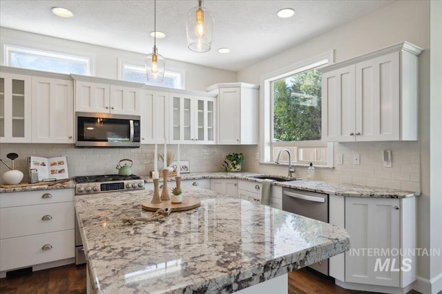 kitchen featuring a sink, plenty of natural light, stainless steel appliances, and white cabinets