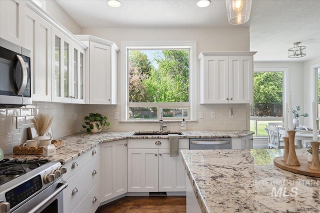 kitchen featuring tasteful backsplash, stainless steel appliances, and white cabinetry