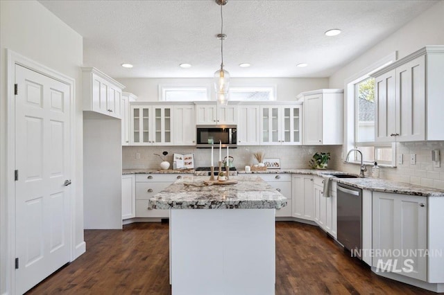 kitchen featuring a sink, appliances with stainless steel finishes, white cabinetry, and glass insert cabinets