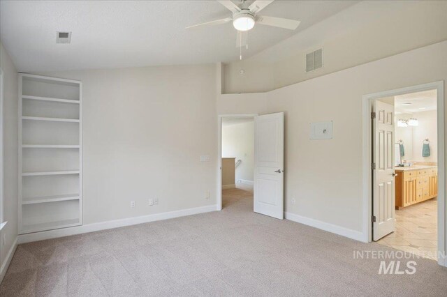 unfurnished bedroom featuring baseboards, light colored carpet, ensuite bath, and visible vents