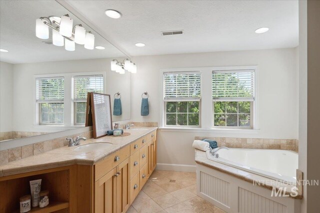 bathroom featuring visible vents, a sink, tile patterned floors, and double vanity