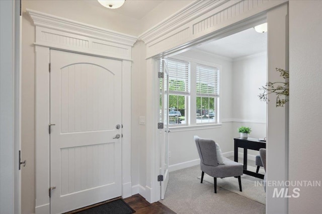 foyer with crown molding and baseboards