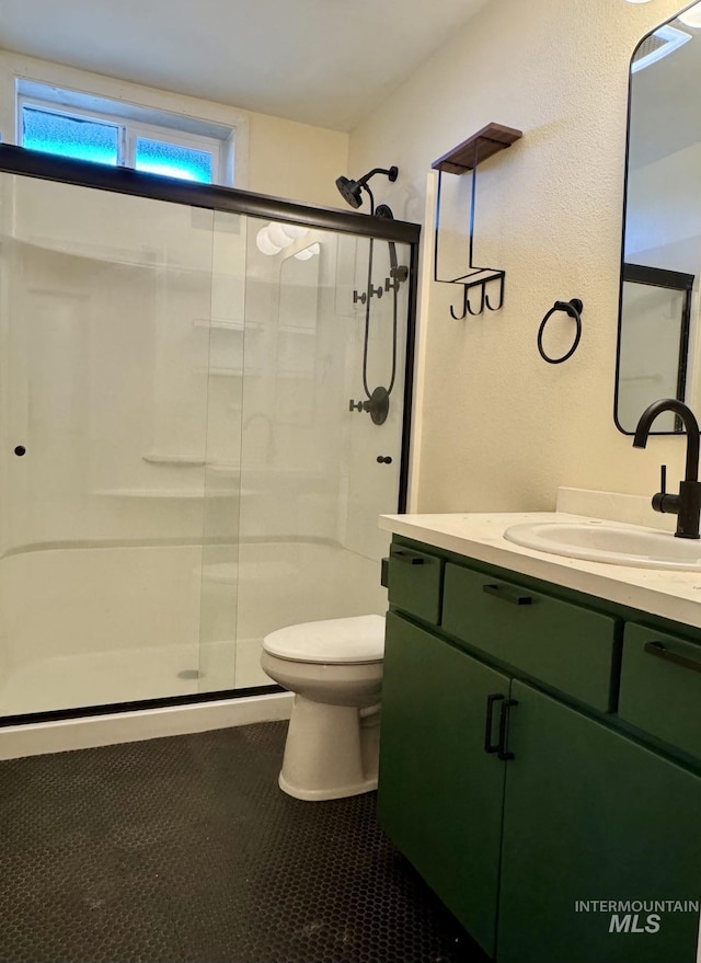 23212NDAVEN 2nd Ave N, Lewiston, ID 83501 - full bathroom with a stall shower, tile patterned flooring, vanity, and toilet