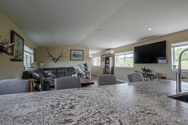13005 Lake Shore Dr, Nampa, ID 83686 - kitchen with an AC wall unit, recessed lighting, vaulted ceiling, and stone countertops