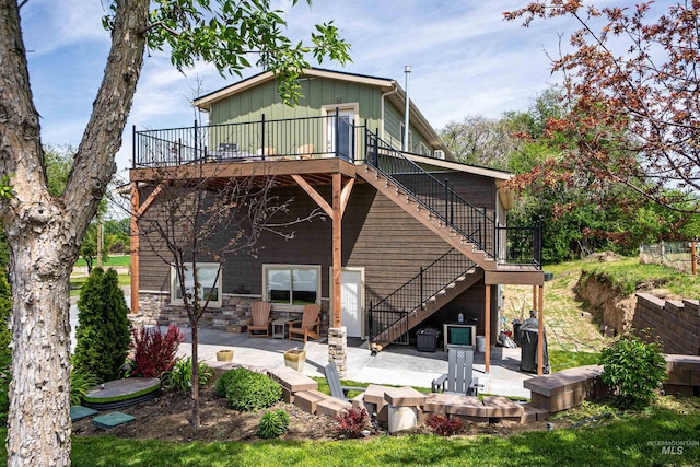 13005 Lake Shore Dr, Nampa, ID 83686 - rear view of house with board and batten siding, stone siding, a patio area, stairs, and a deck