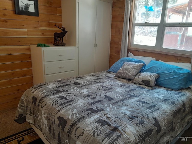 carpeted bedroom with wooden walls