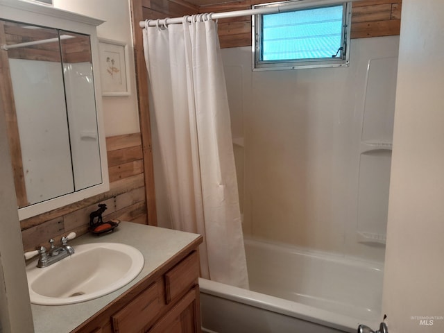 bathroom featuring wooden walls, shower / bath combo with shower curtain, and vanity with extensive cabinet space