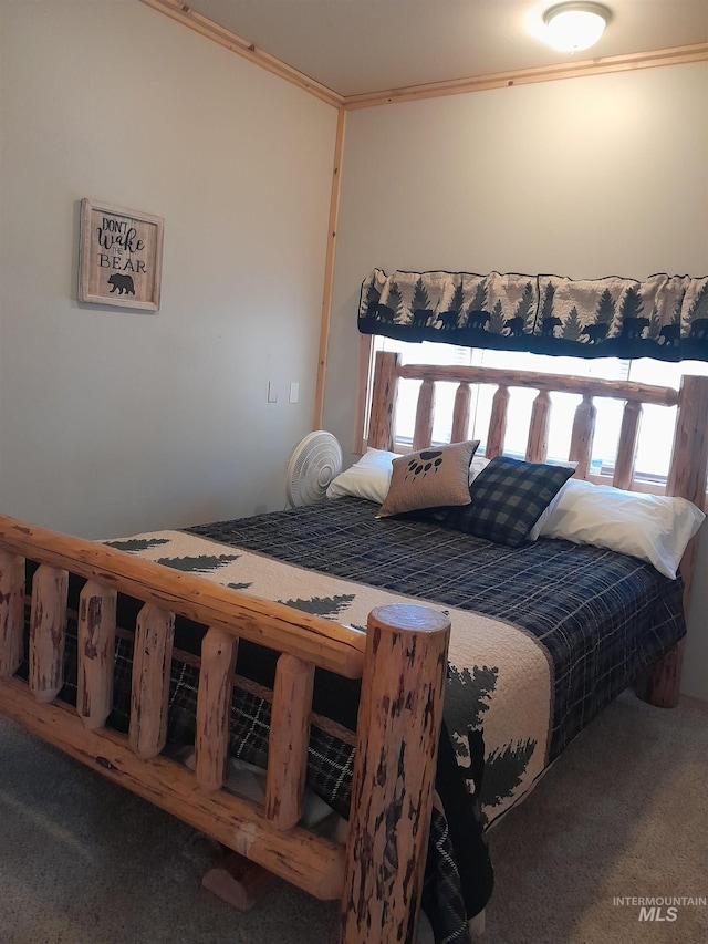 bedroom featuring dark colored carpet and ornamental molding