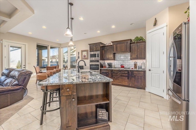 4595 N Tirso Ave, Meridian, ID 83646 - kitchen featuring backsplash, a sink, light stone counters, open floor plan, and stainless steel appliances