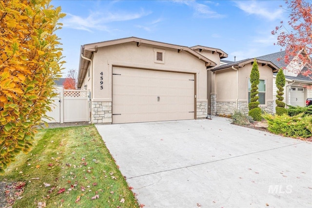 4595 N Tirso Ave, Meridian, ID 83646 - view of front of house featuring fence, an attached garage, stone siding, stucco siding, and driveway