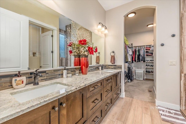 4595 N Tirso Ave, Meridian, ID 83646 - bathroom with double vanity, tasteful backsplash, a sink, and wood finished floors