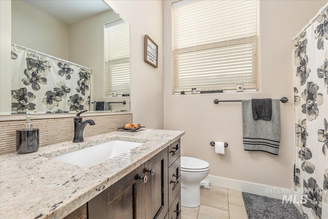 4595 N Tirso Ave, Meridian, ID 83646 - bathroom with vanity, toilet, tile patterned floors, baseboards, and decorative backsplash