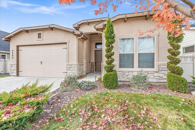 4595 N Tirso Ave, Meridian, ID 83646 - view of front of house with stucco siding, an attached garage, driveway, and stone siding