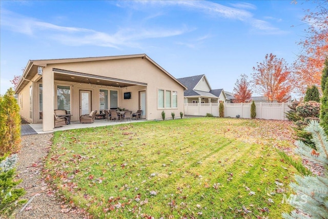 4595 N Tirso Ave, Meridian, ID 83646 - rear view of property with a lawn, fence, a patio area, and stucco siding