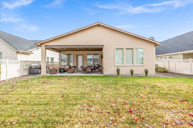 4595 N Tirso Ave, Meridian, ID 83646 - rear view of house with a patio area, an outdoor hangout area, a fenced backyard, a yard, and stucco siding